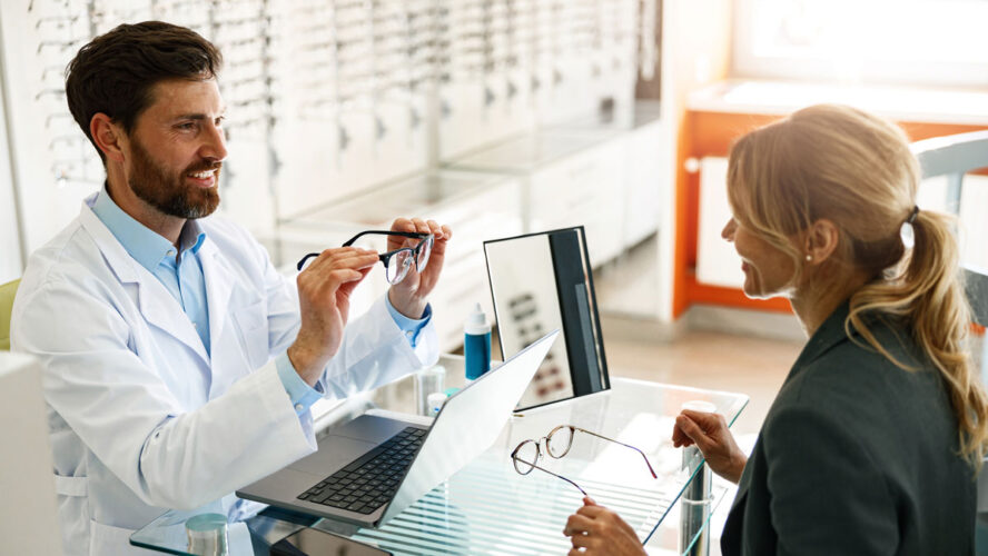 An ophthalmologist consults a client at his workplace in an optician's shop