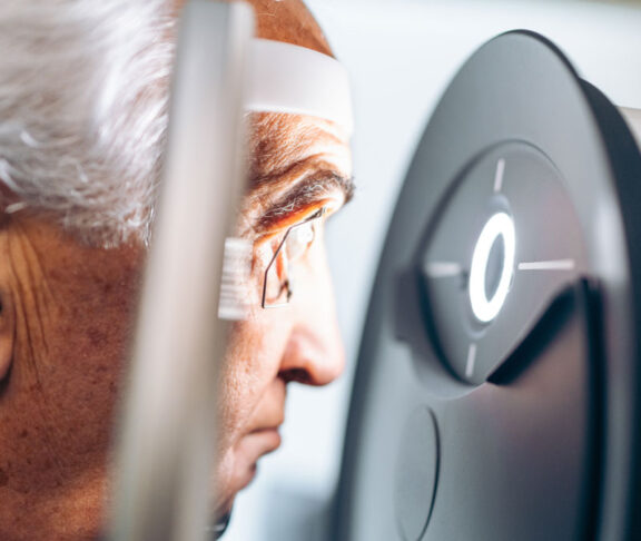 Elderly patient receives a glaucoma screening using a laser eye scanner.