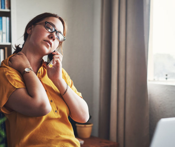 Cropped shot of an attractive young businesswoman sitting alone in her home office and feeling stressed while using her cellphone
