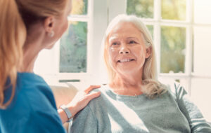 Shot of a senior woman being supported by her nurse at home