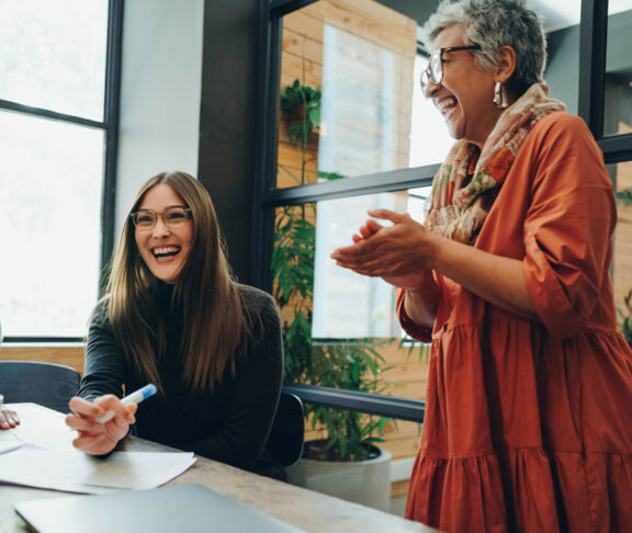 Group of successful businesspeople laughing cheerfully during an office meeting. Team of multicultural businesspeople collaborating in a creative workplace.