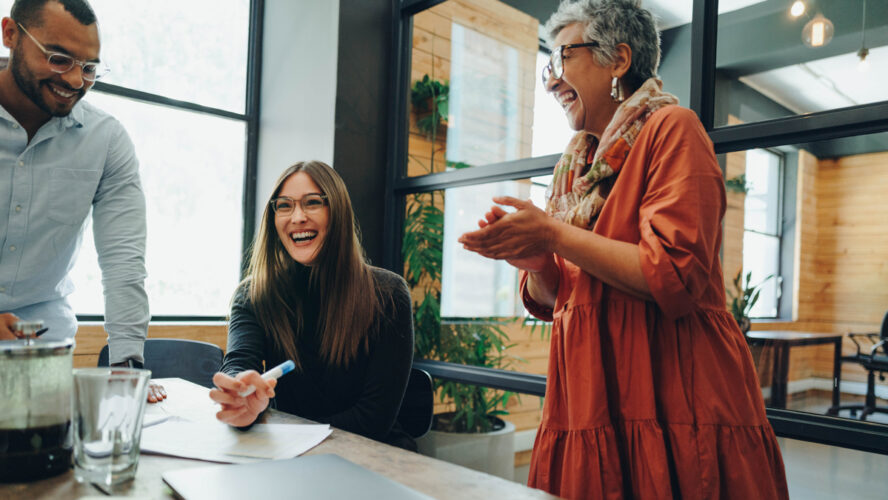 Group of successful businesspeople laughing cheerfully during an office meeting. Team of multicultural businesspeople collaborating in a creative workplace.