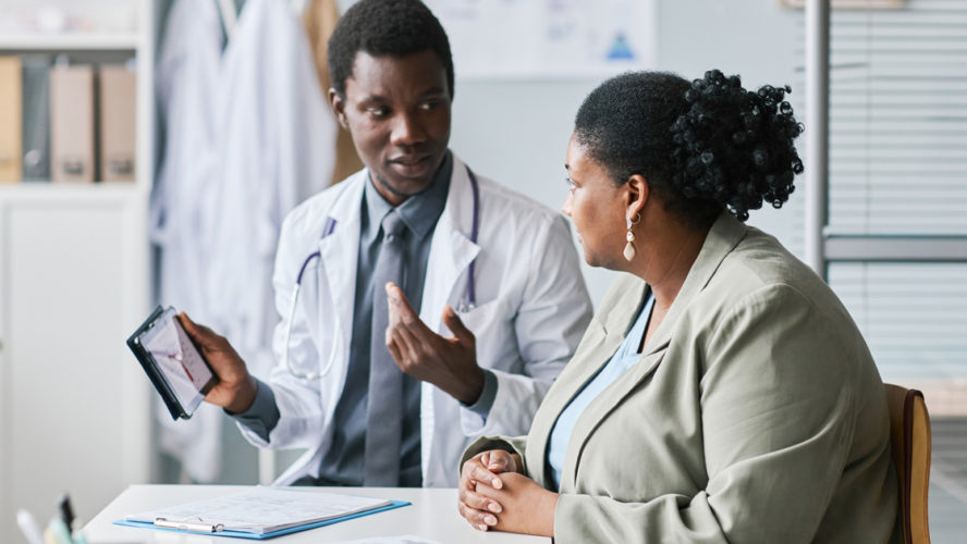 Side view portrait of a woman listening to doctor in clinic
